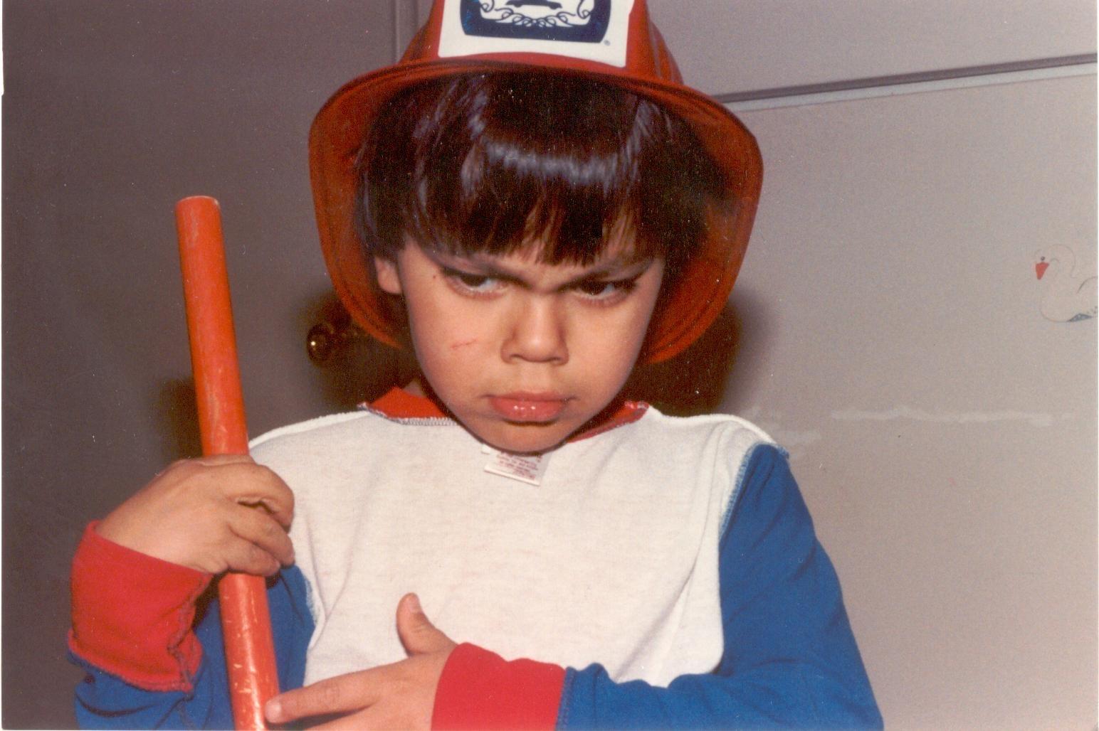 A child wearing a hat and holding a baseball bat