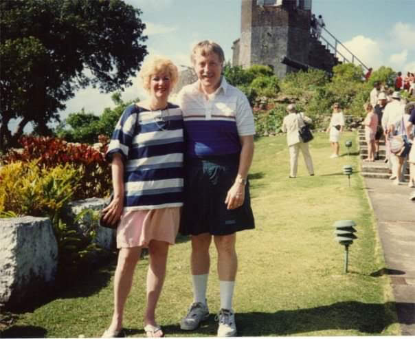 A man and woman standing together in a garden