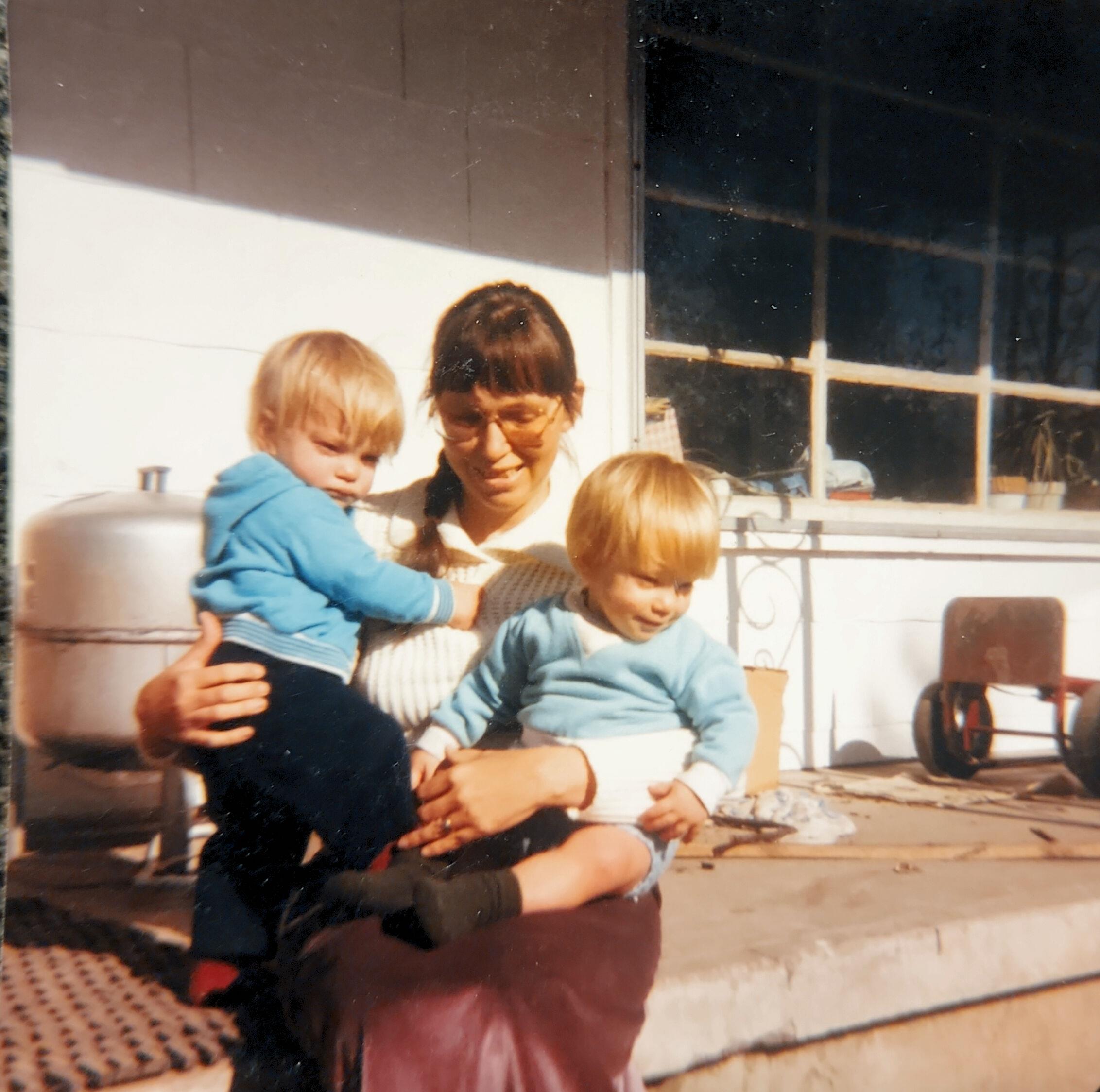 A woman holding two children