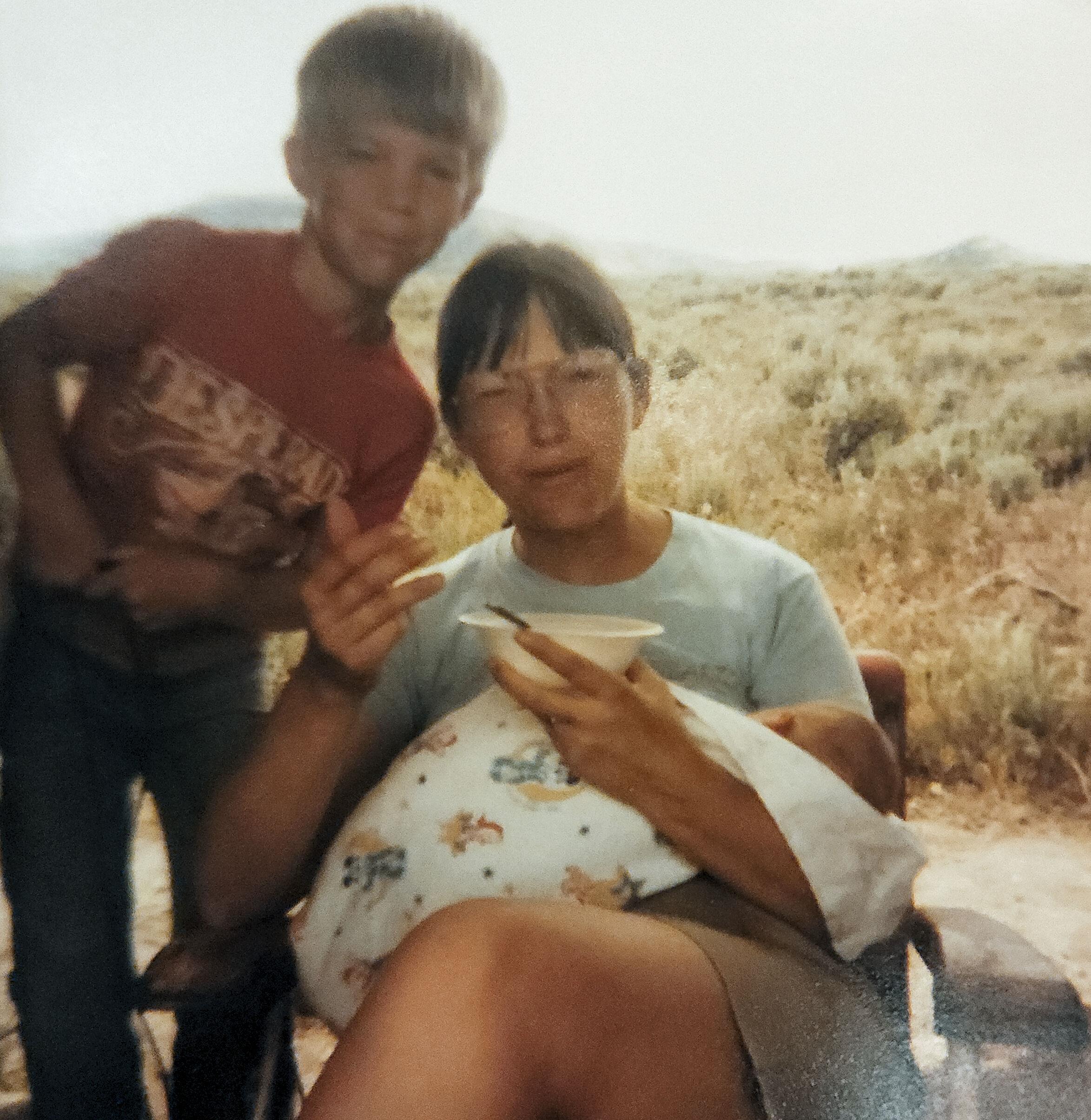A woman sitting in a chair with a boy in the background