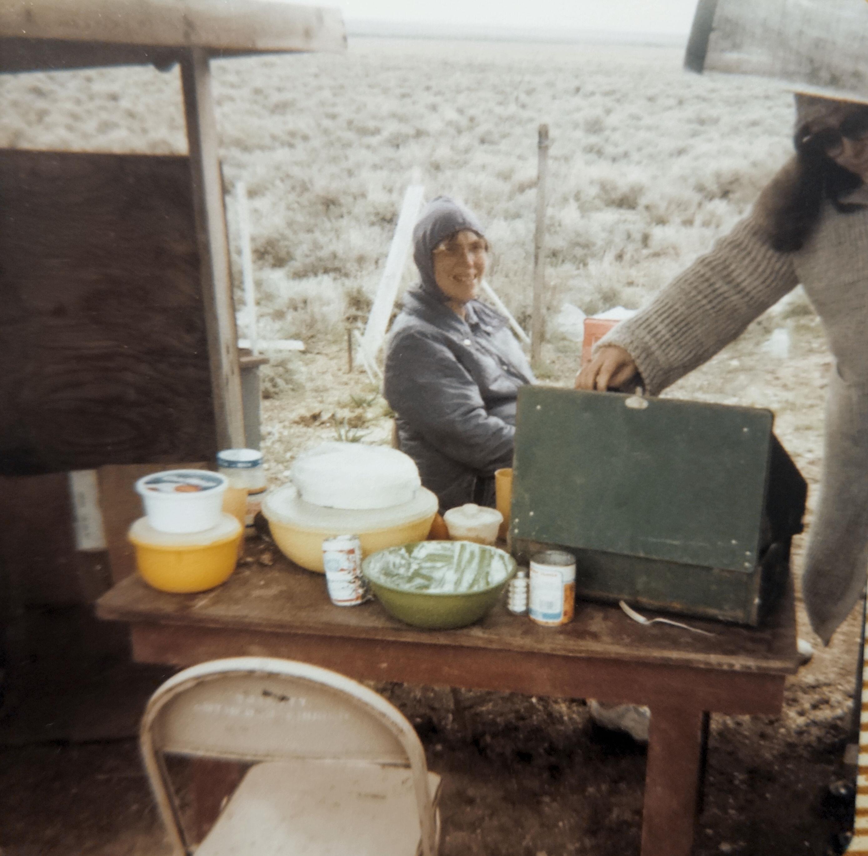 A woman standing next to a table with food